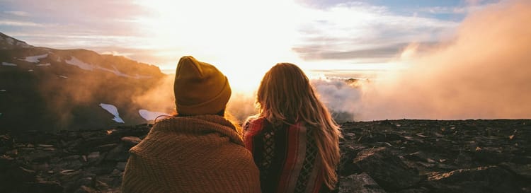 couple looking out over mysterious landscape at sunrise