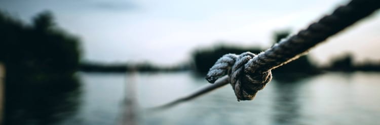 long rope leading out into a lake with a knot visible in foreground