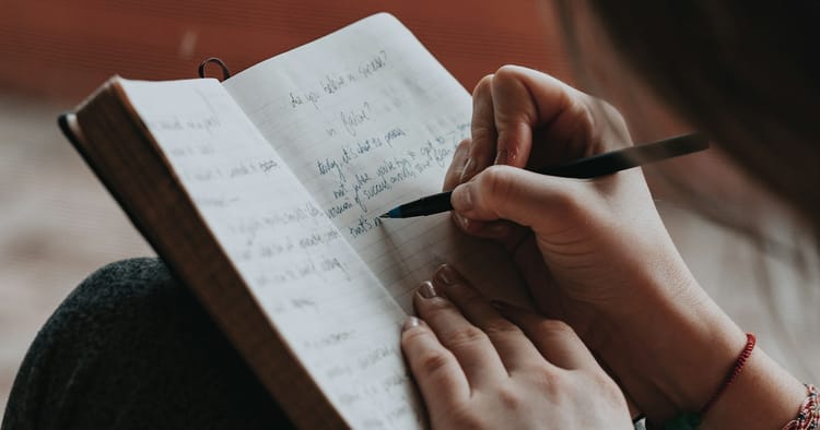 person writing in a notebook