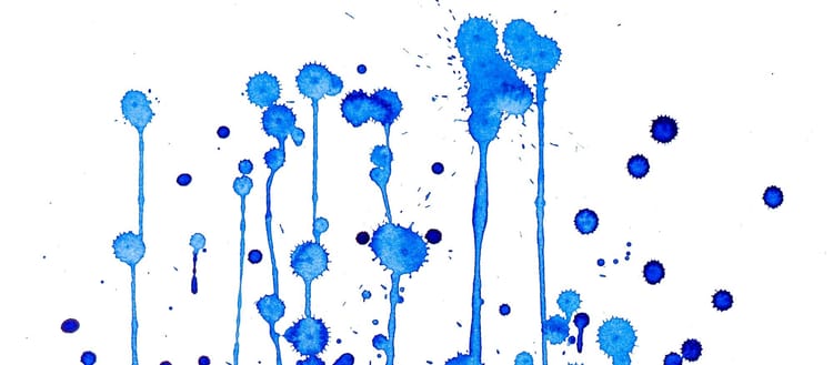 blue ink splatters on a white surface