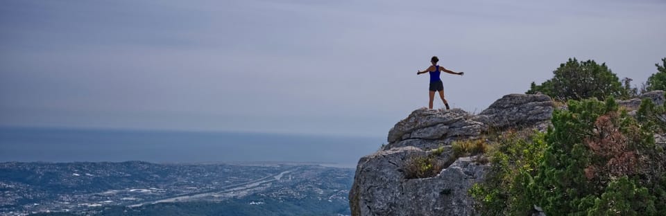 person standing on an outcropping of rock high above a landscape