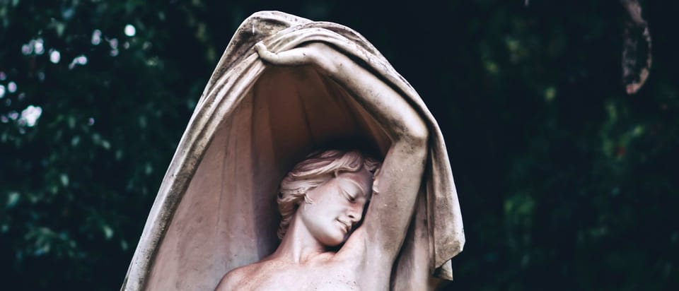 statue of a woman holding a cloth over her head