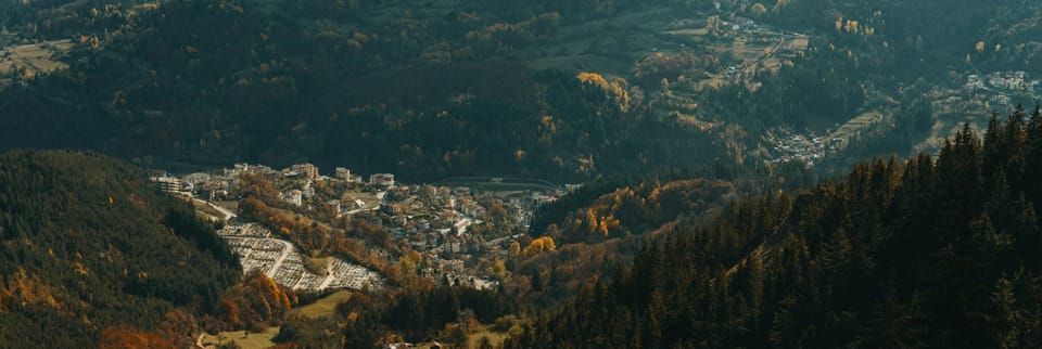 sun rising over mountains illuminating village in the valley below